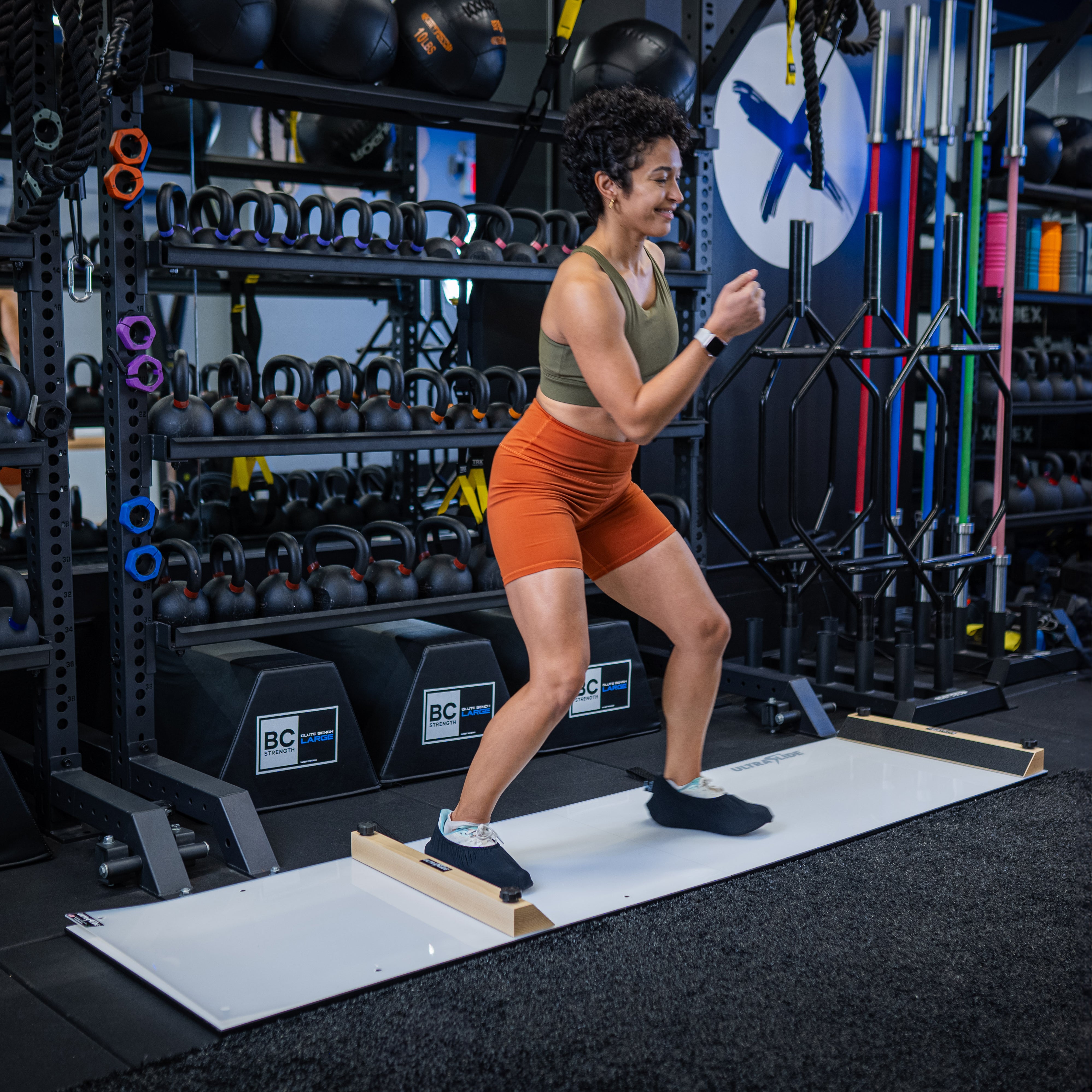 Woman exercising on an ULTRASLIDE slide board in a gym setting