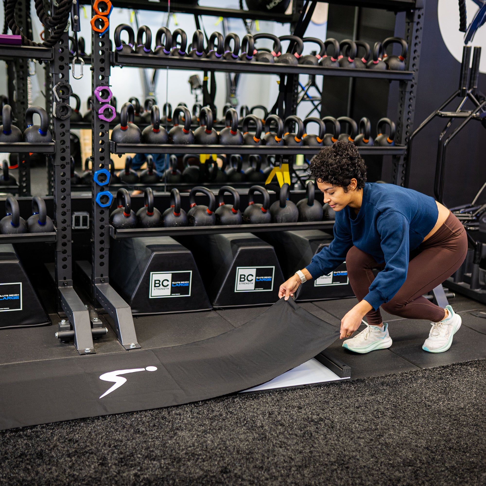 Person cover an ULTRASLIDE slide board with cover with equipment in the background