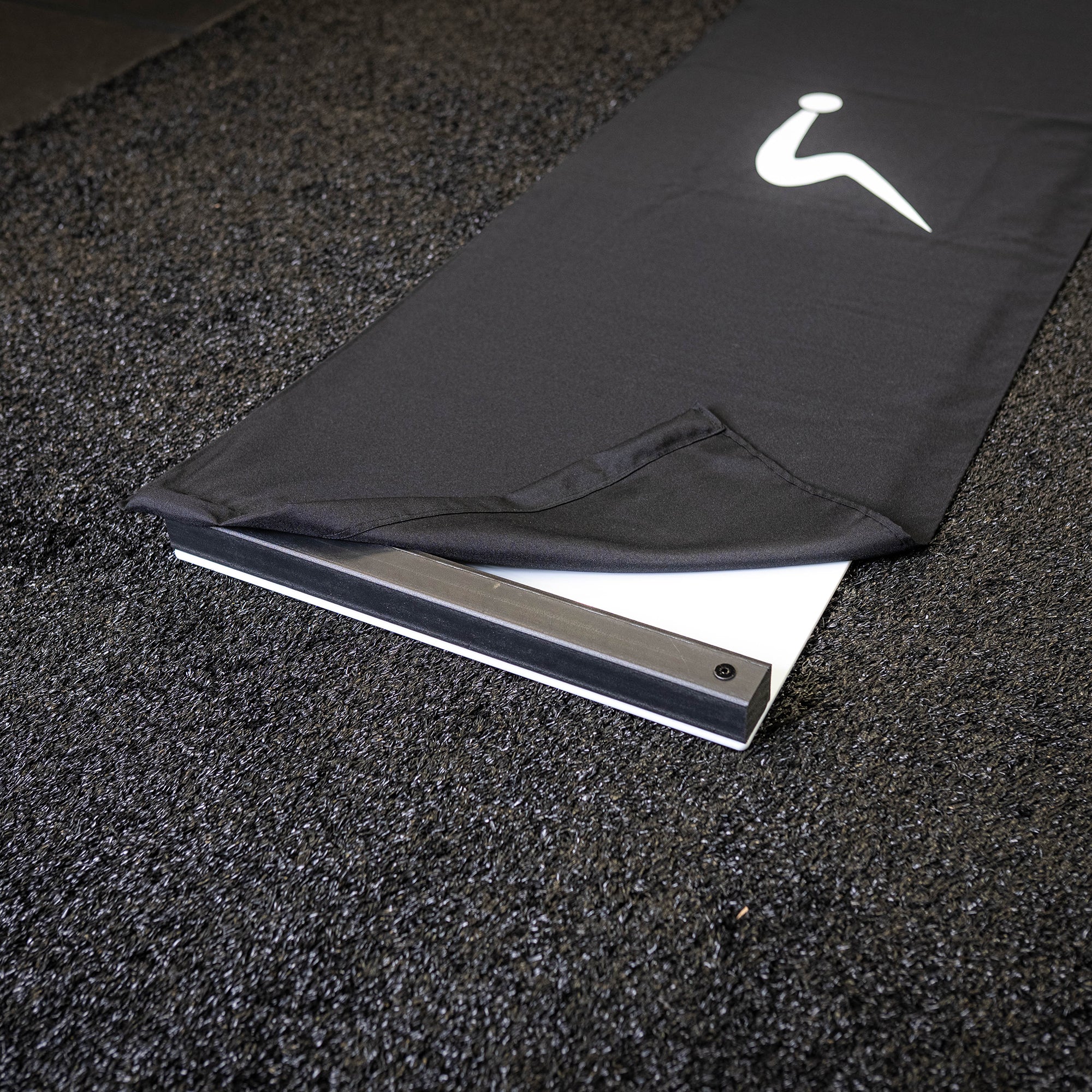 Peeled back corner of an ULTRASLIDE slide board cover, revealing the board's bumper