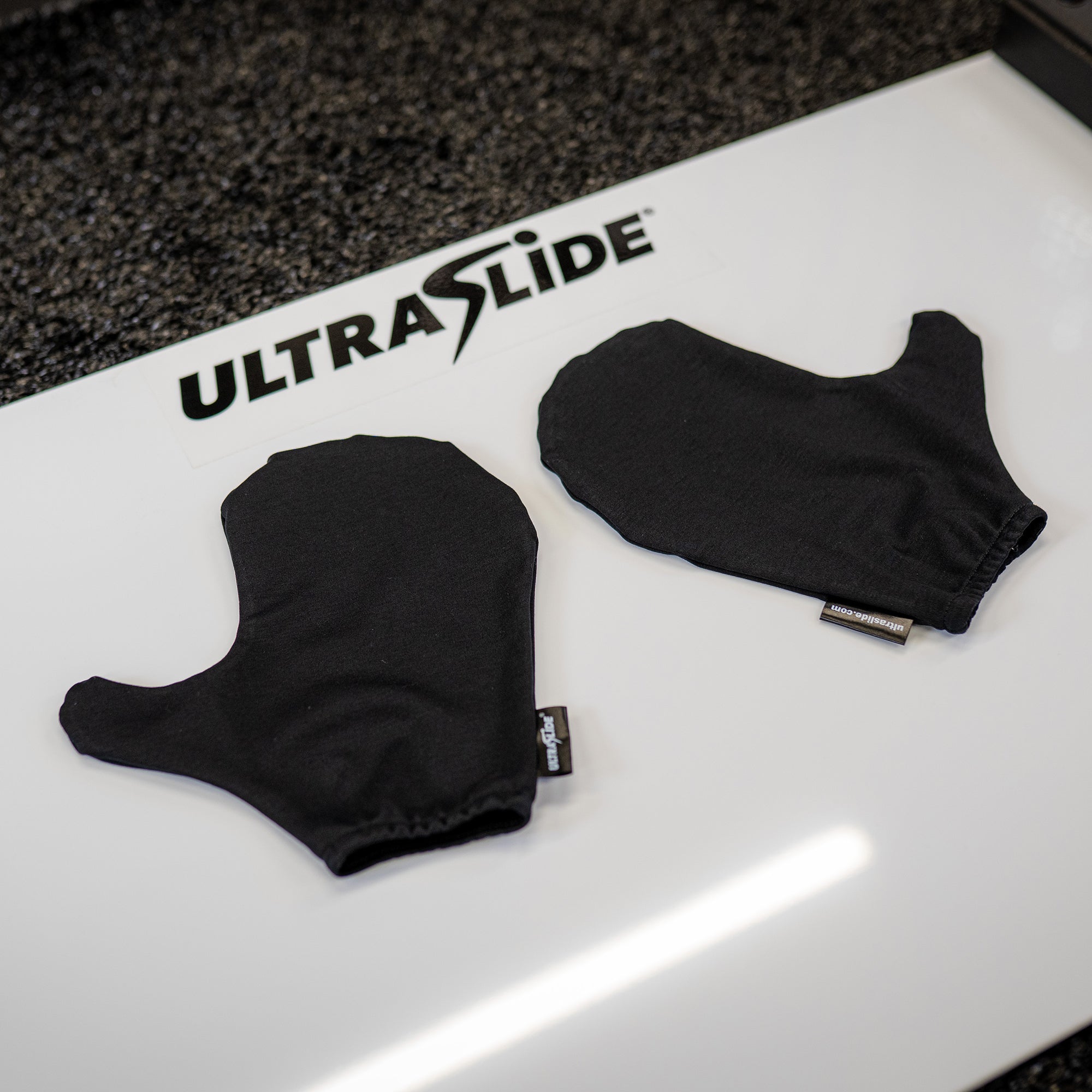 Black ULTRASLIDE slide board mitts on a slide board.