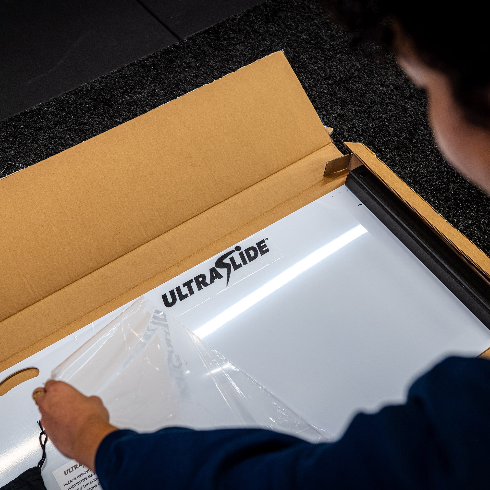Person opening an ULTRASLIDE slide board box