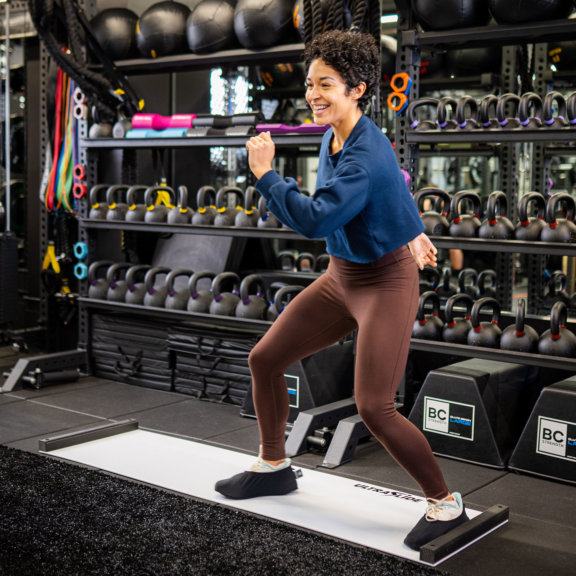 Woman exercising on an ULTRASLIDE slide board in a gym setting