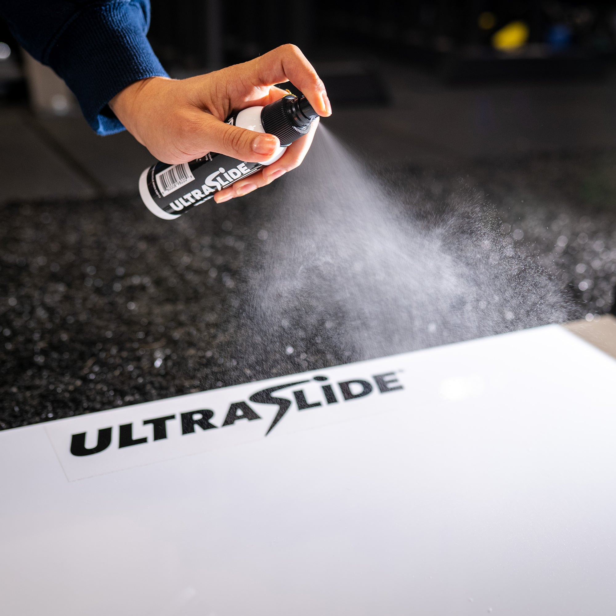 ULTRASLIDE Slide Polish being sprayed on a slide board