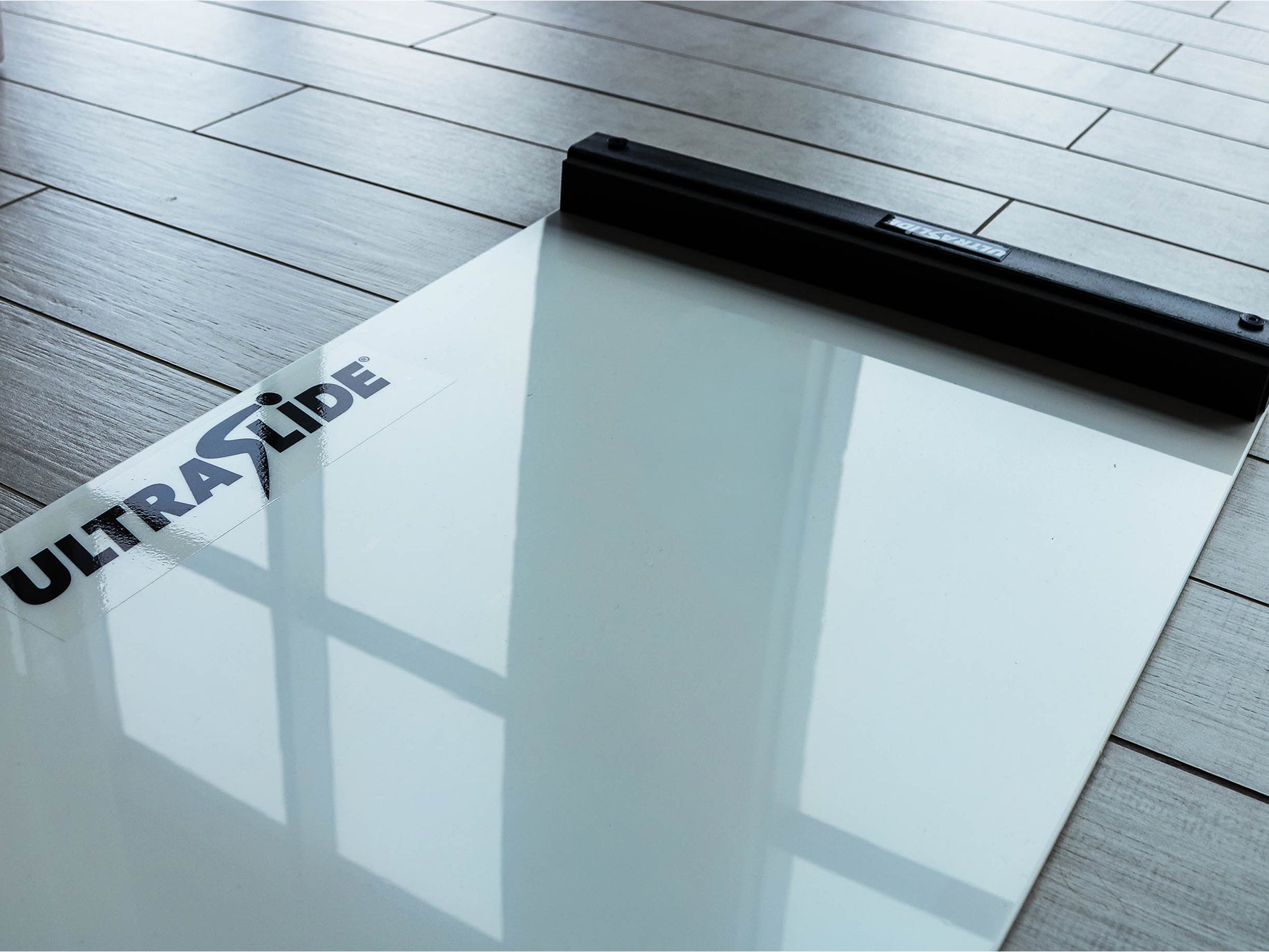 Natural light reflecting on the surface of an Ultraslide 6 slideboard on a wooden floor